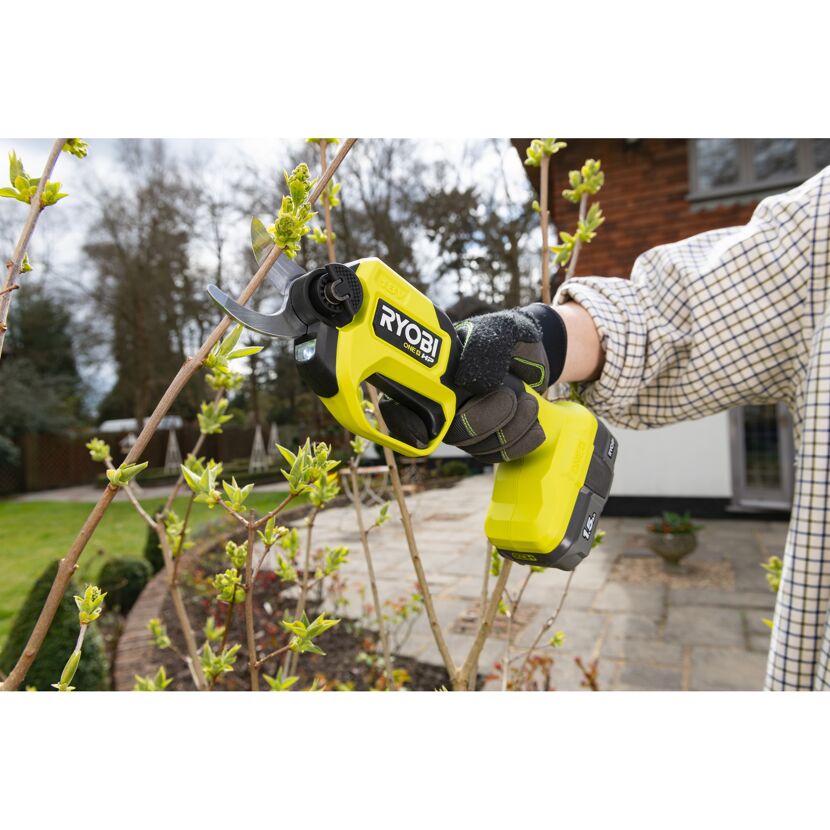 Person schneidet mit Akku-Gartenschere einen Ast