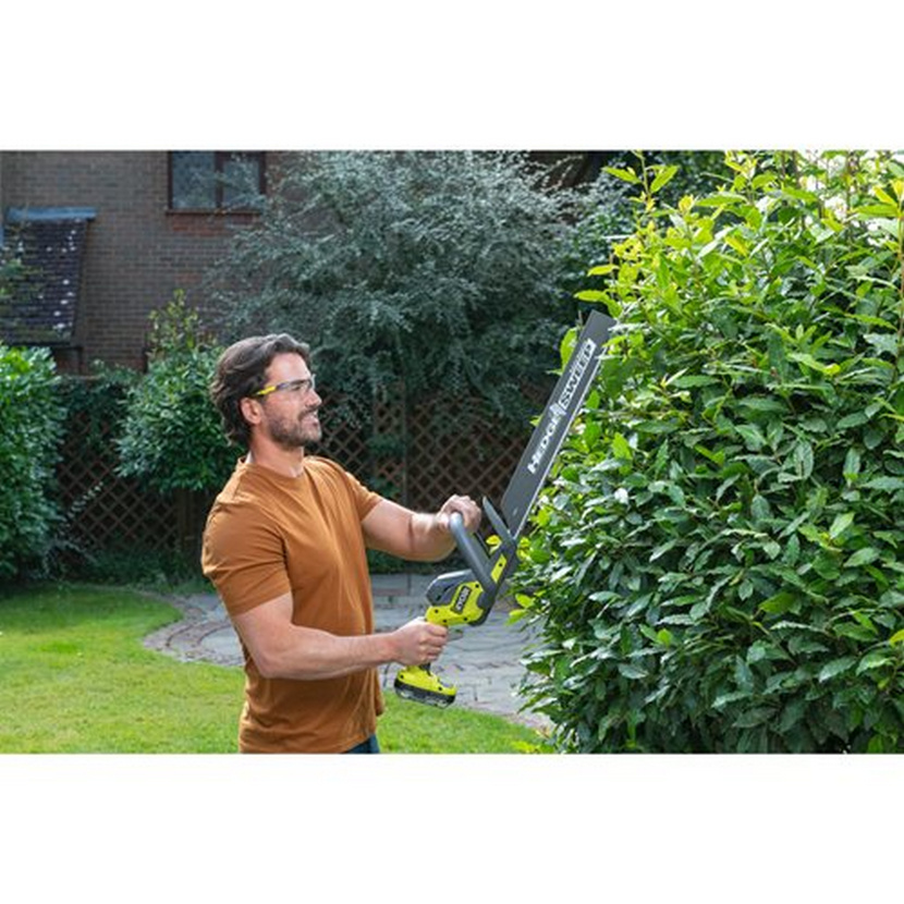 Person schneidet Hecke mit Akku-Heckenschere