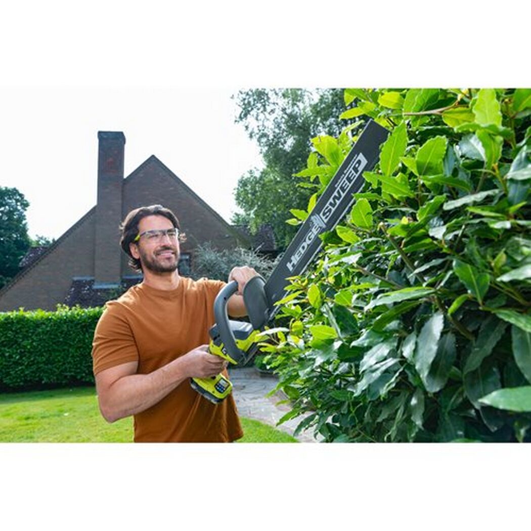 Person schneidet Hecke mit Akku-Heckenschere