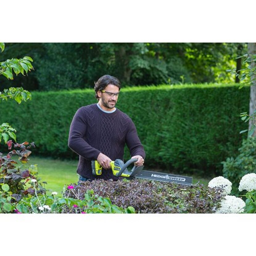 Person schneidet Hecke mit Akku-Heckenschere