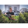 Person schneidet eine Hecke mit einer Akku-Heckenschere.