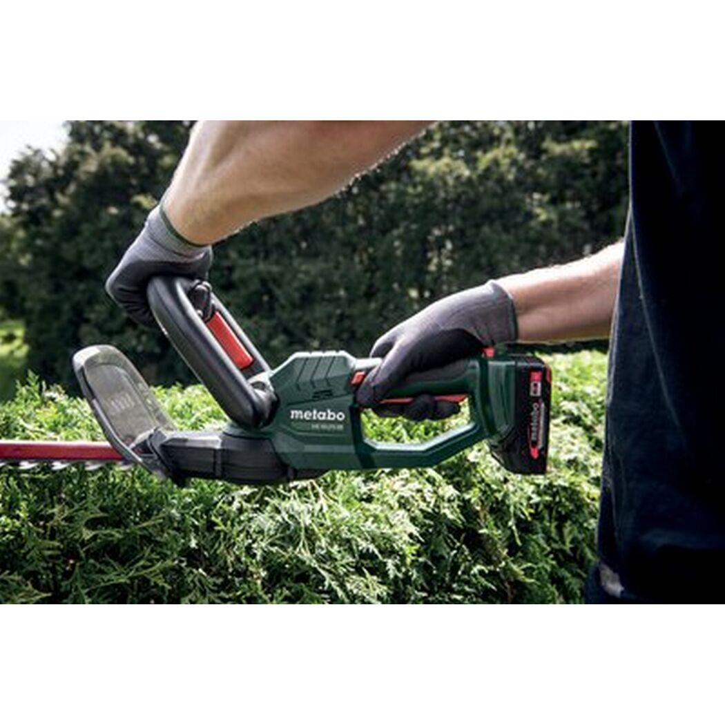 Person schneidet eine Hecke mit einer Akku-Heckenschere.