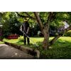 Person verwendet Akku-Rasentrimmer im Garten.
