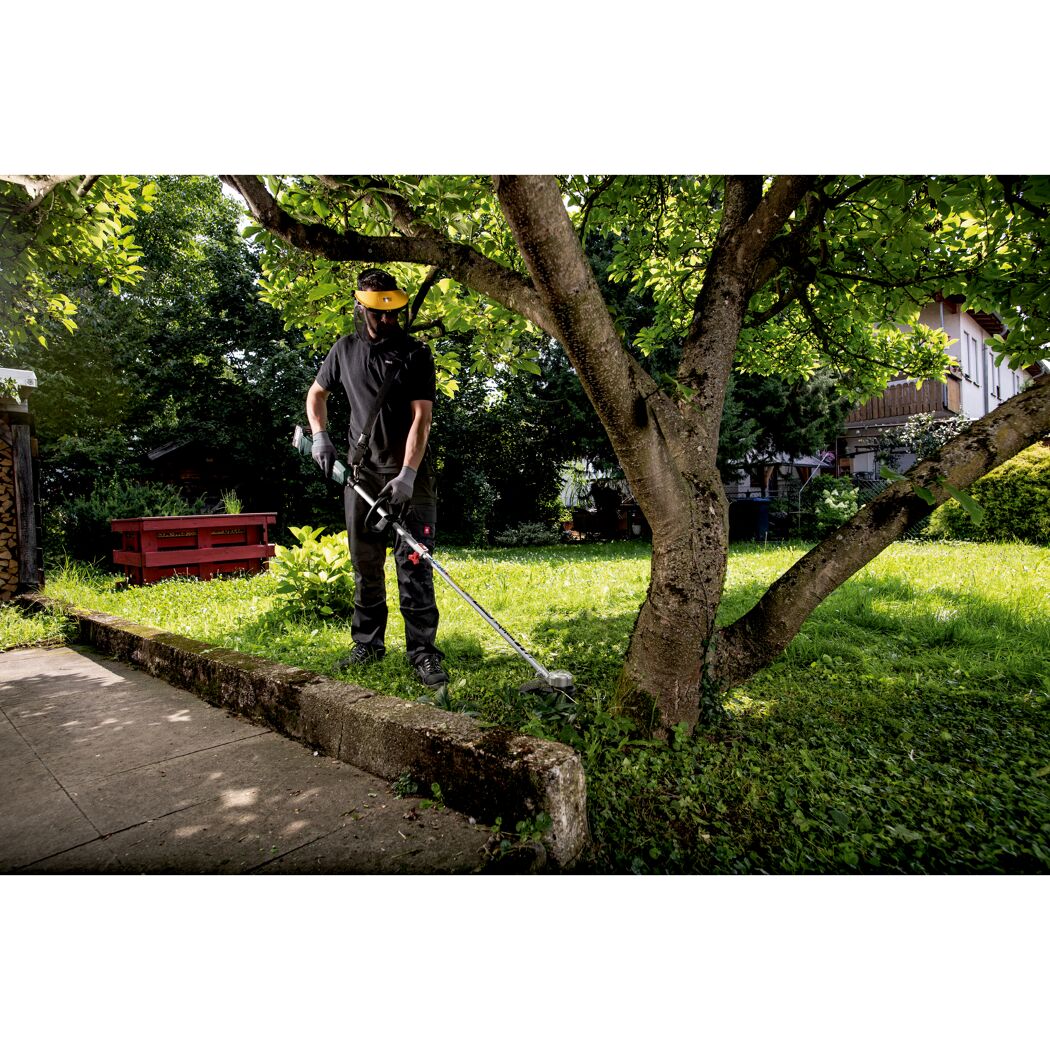 Person verwendet Akku-Rasentrimmer im Garten.