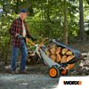Person transportiert Holzscheite mit der Worx Aerocart Schubkarre.