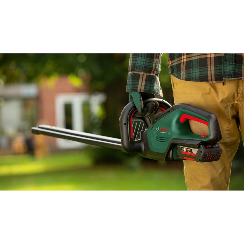 Person hält eine Bosch AdvancedHedgeCut 36V Heckenschere.