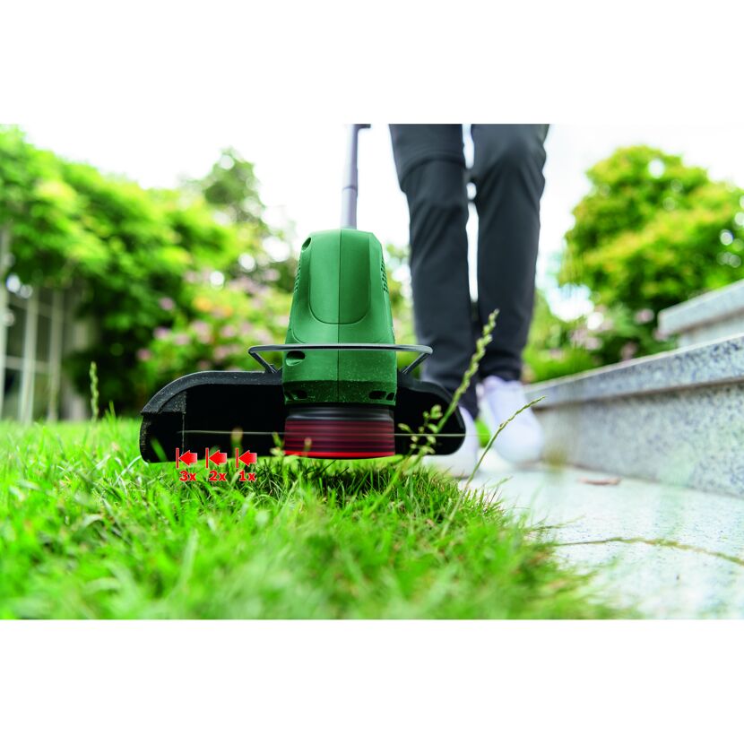 Person verwendet einen Rasentrimmer EasyGrassCut 18