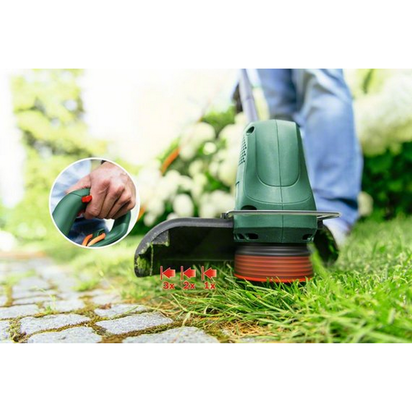 Person trimmt mit dem EasyGrassCut23 Rasentrimmer Gras.