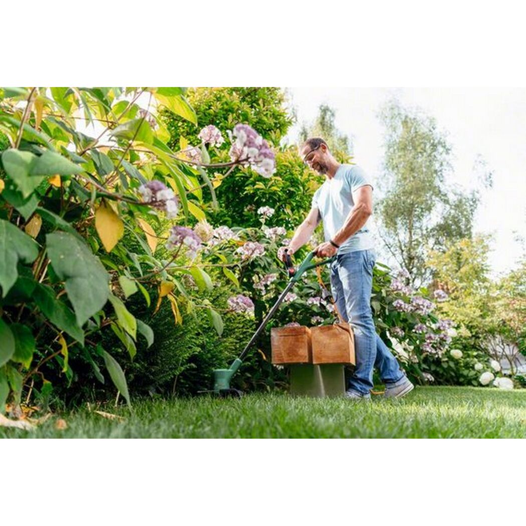 Person verwendet EasyGrassCut 23 Rasentrimmer