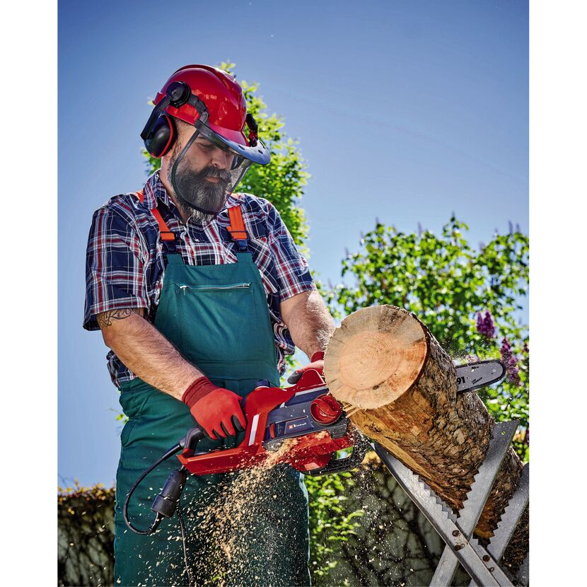 Person sägt Holz mit einer elektrischen Kettensäge