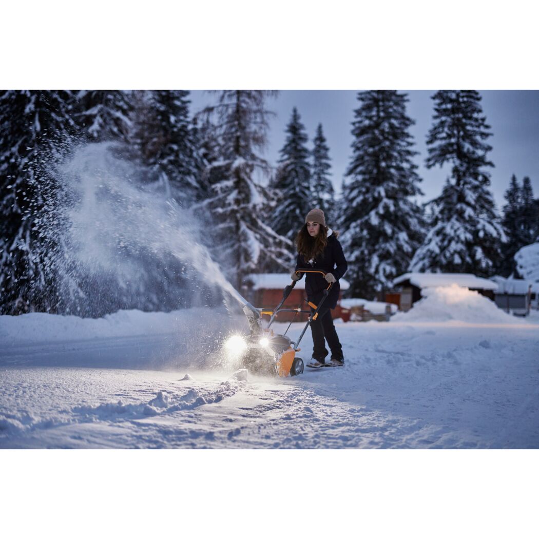 Person räumt Schnee mit Schneefräse