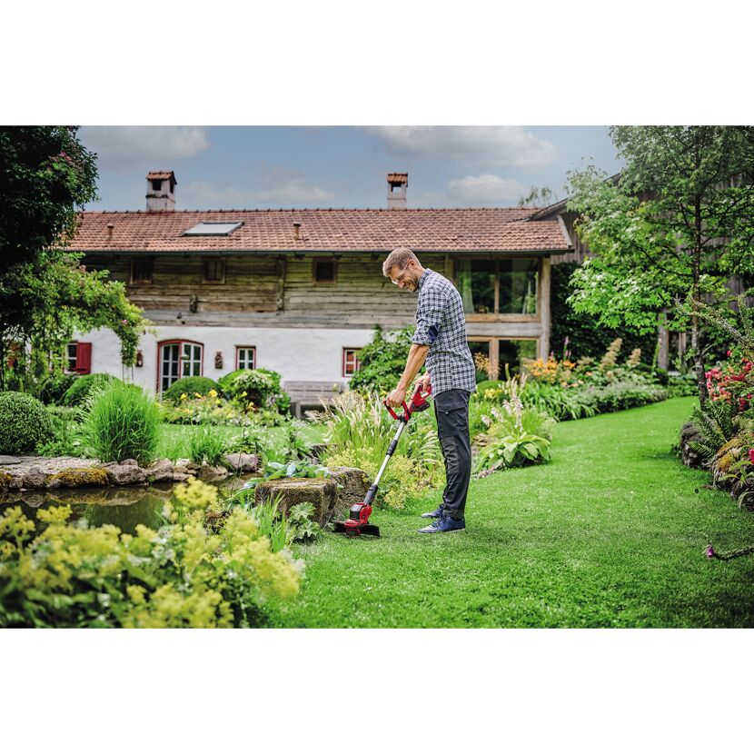 Person verwendet A-Trimmer im Garten.