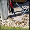 Person entfernt Laub mit Laubbläser von Terrasse.
