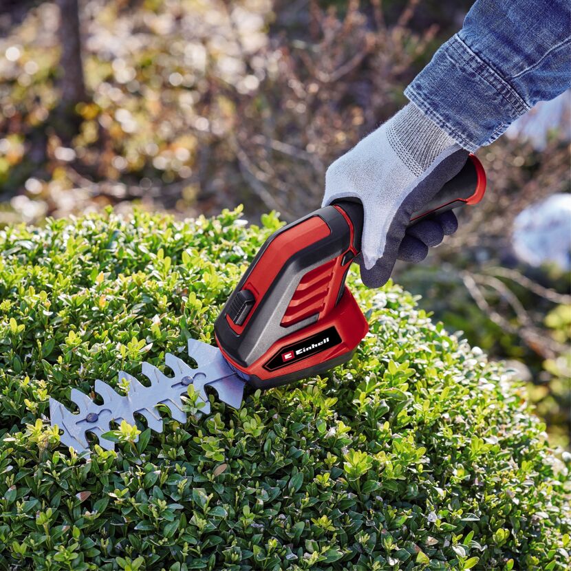 Person schneidet Hecke mit Akku-Grasschere