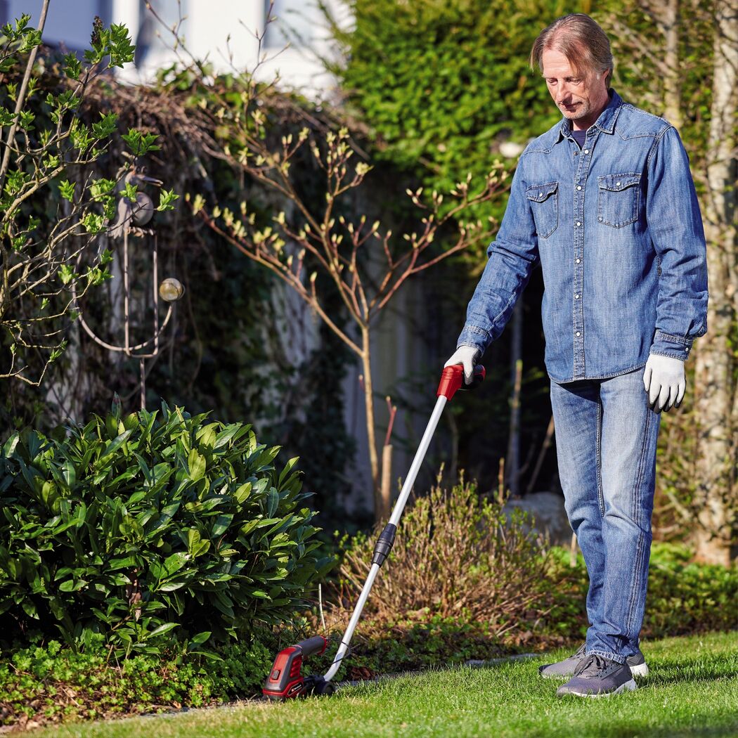 Person mäht Rasenkante mit Akku-Grasschere