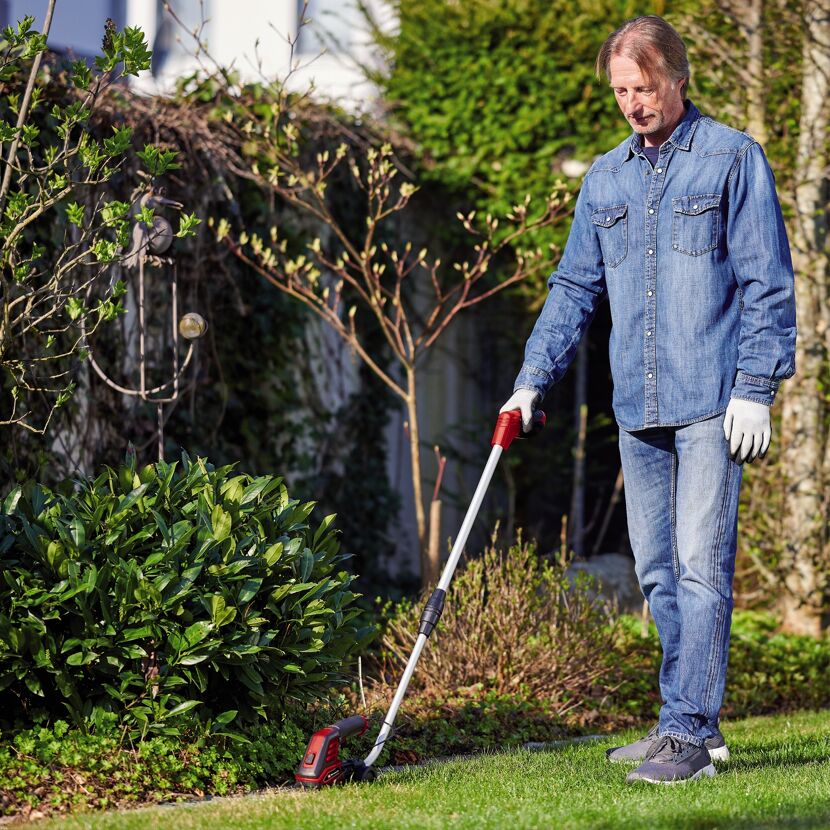 Person mäht Rasenkante mit Akku-Grasschere