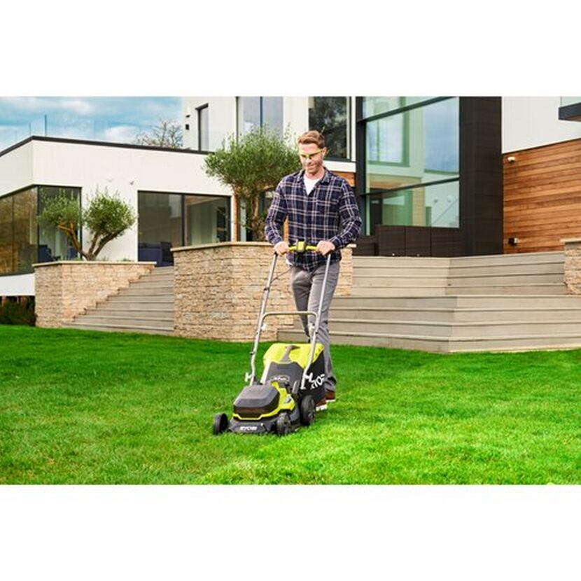 Person mäht Rasen mit RYOBI Akku-Rasenmäher.