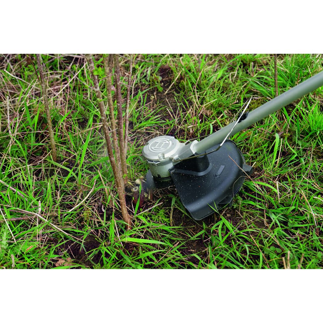 Rasentrimmer entfernt Gras um einen Baum