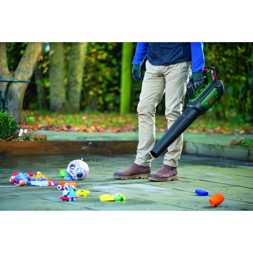 Person verwendet Laubbläser, um Spielzeug zu entfernen.