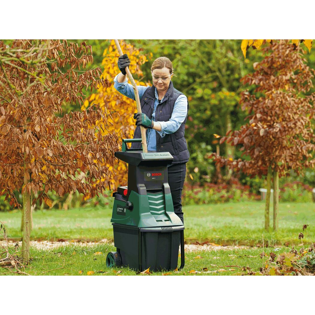 Person verwendet einen Bosch Gartenhäcksler AXT 25 D.