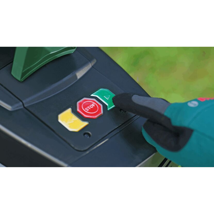 Person drückt den Startknopf eines Gartenhäckslers