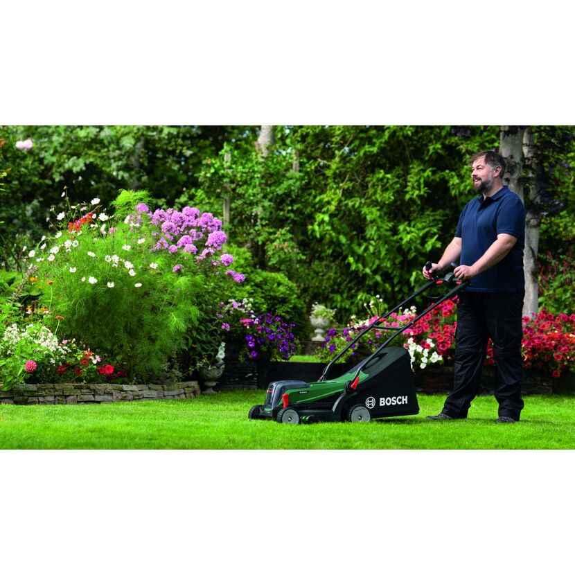 Person mäht Rasen mit Bosch Rasenmäher.