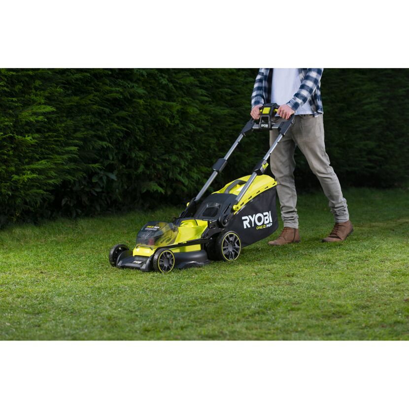 Person mäht Rasen mit RYOBI Akku-Rasenmäher.