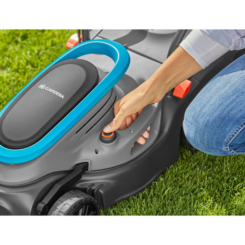 Person startet einen Gardena Elektro-Rasenmäher.