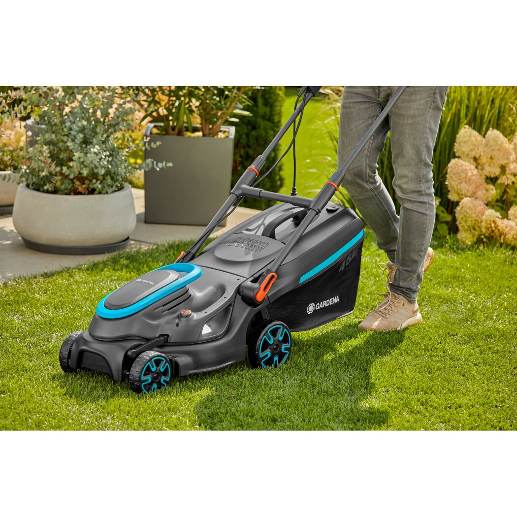 Person mäht Rasen mit Gardena Elektro-Rasenmäher.