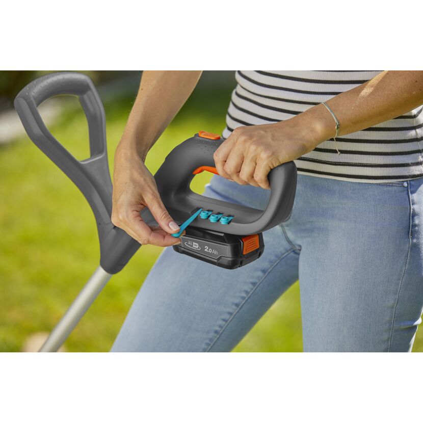 Person wechselt den Akku eines Akku-Trimmers SmallCut.