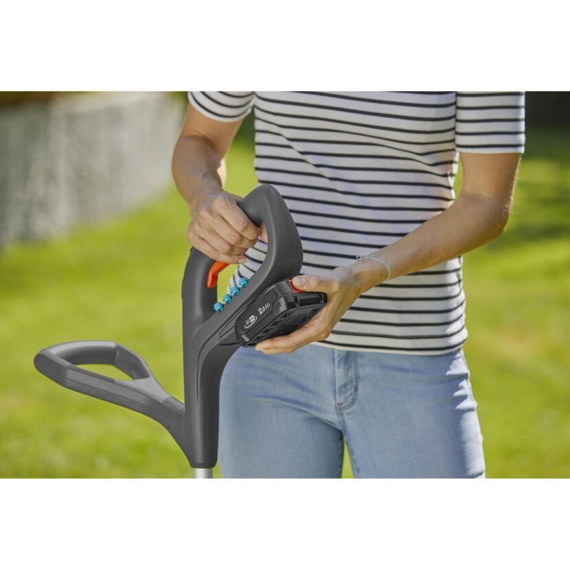 Person setzt Akku in den Akku-Trimmer SmallCut ein.
