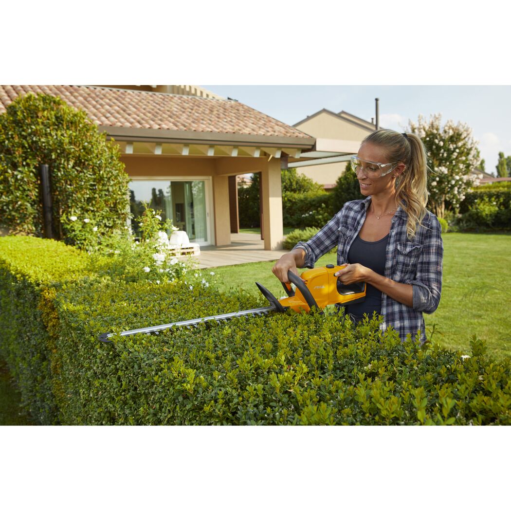 Person schneidet eine Hecke mit einer Akku-Heckenschere