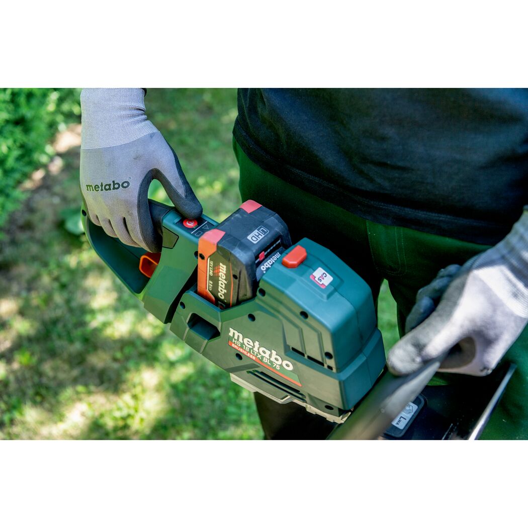 Person setzt Akku in Metabo Heckenschere ein