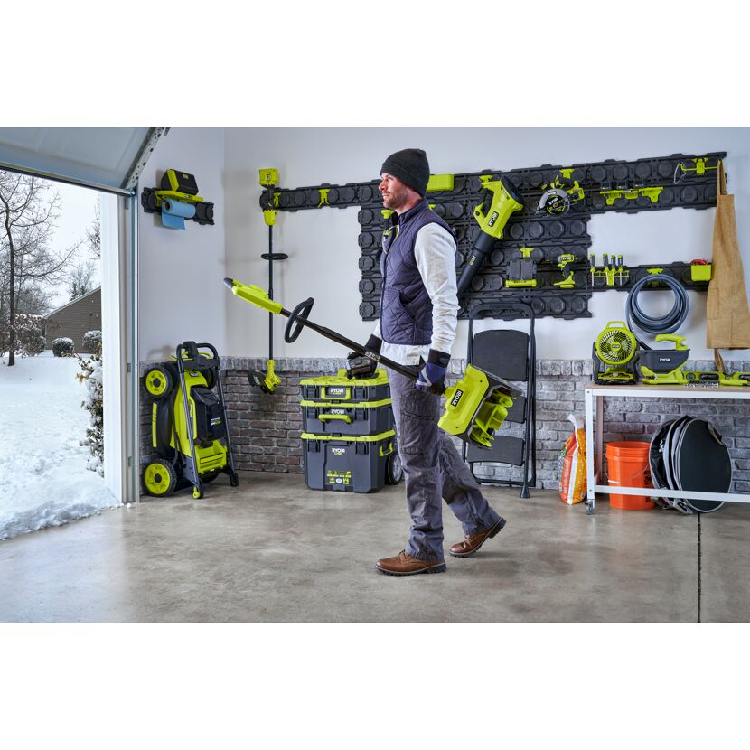 Person trägt eine RYOBI Akku-Schneefräse