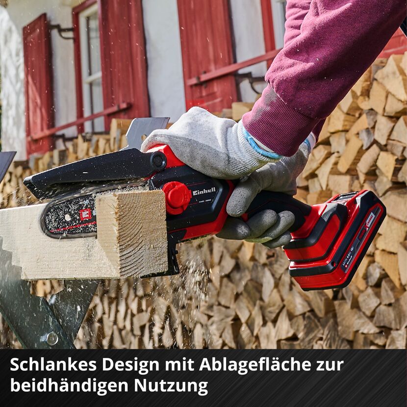 Person sägt Holz mit Akku-Kettensäge von Einhell.