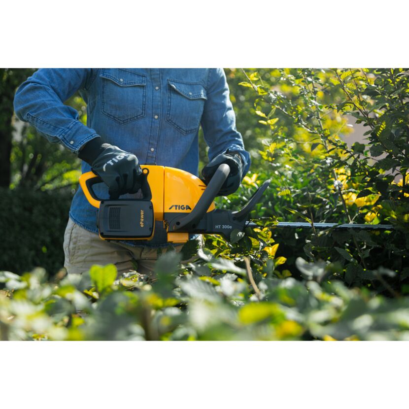 Person schneidet Hecke mit Akku-Heckenschere