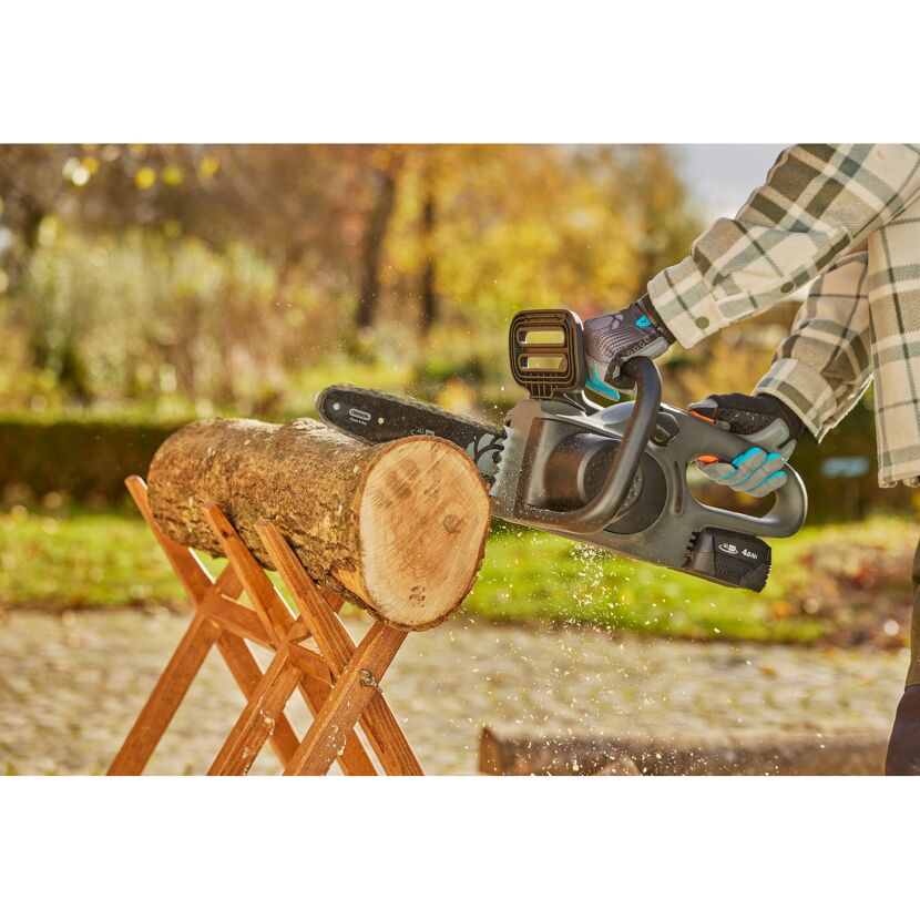 Person sägt Holz mit Kettensäge