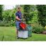 Person befüllt Häcksler mit Gartenabfällen
