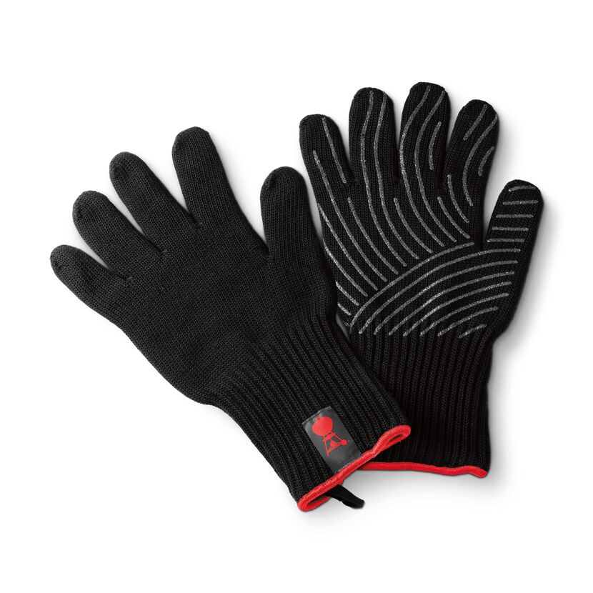 Ein Paar schwarze Grillhandschuhe mit roter Paspelierung und Silikonstreifen.