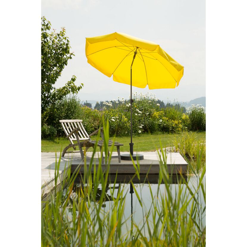 Gelber Sonnenschirm neben einem Gartenstuhl und kleinem Teich.
