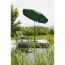 Grüner Sonnenschirm und Gartenliege am Teich