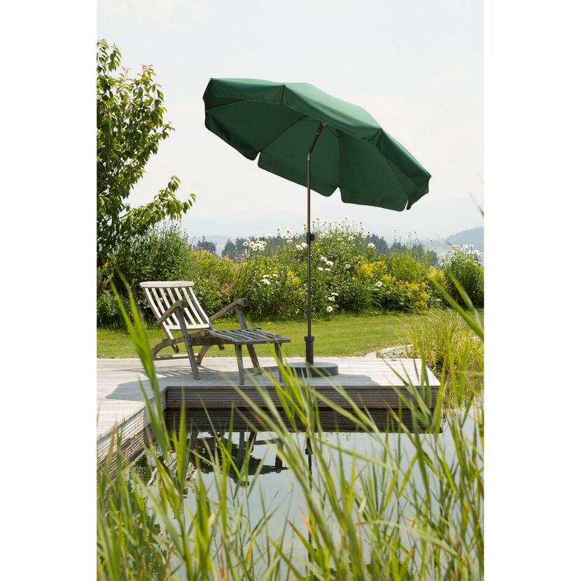 Grüner Sonnenschirm und Gartenliege am Teich