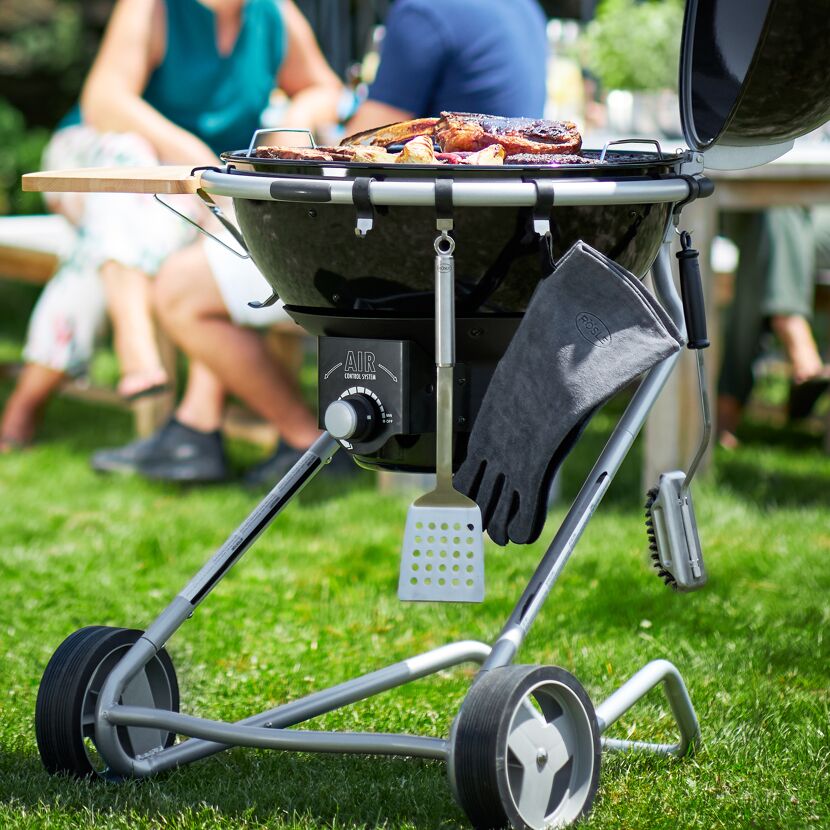Runder Grill mit Grillgut und Zubehör
