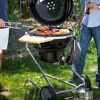Grillen auf einem schwarzen Holzkohlegrill im Garten.