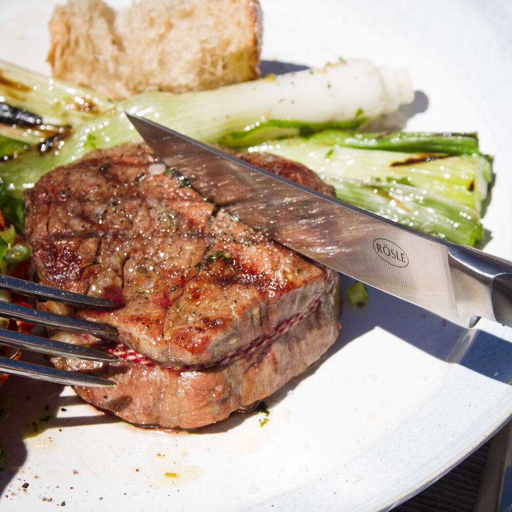 Steak wird mit einem Messer geschnitten.