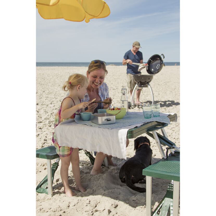 Familie grillt am Strand und isst zu Mittag