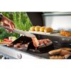 Person grillt Speck mit Speckgriller auf einem Gasgrill.
