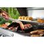 Person grillt Speck mit Speckgriller auf einem Gasgrill.