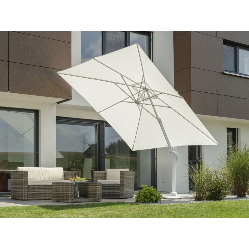 Weißer quadratischer Sonnenschirm beschattet eine Sitzgruppe im Garten