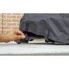 Person befestigt Premium Abdeckhaube am Grill